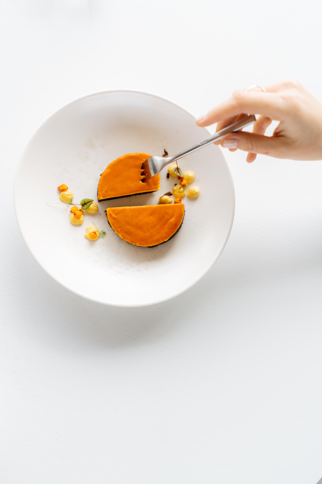 Mano che impiatta un dessert moderno